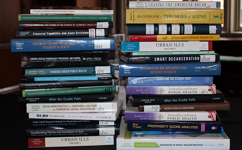 Two stacks of books authored or edited by Brown School faculty and staff