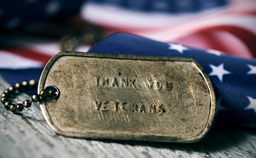 Picture of rusty dog tags against folded american flag