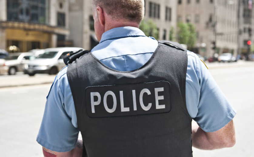 Image of back of police officer in bullet proof vest
