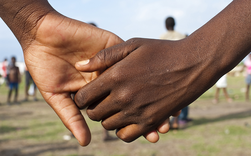 Close-up photo of two African teens holding hands