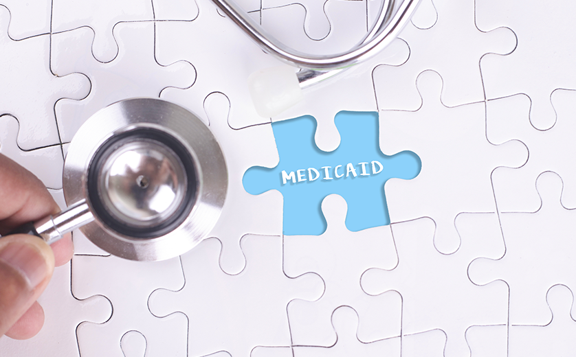A puzzle with a piece missing; a hand holds the piece over a blue space with 'Medicaid' printed in whit