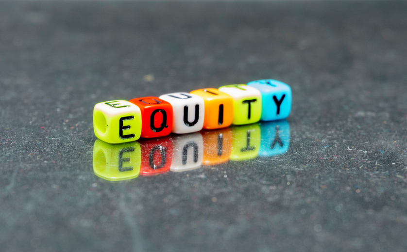 Colored blocks with letters on tabletop that spell 'equity'