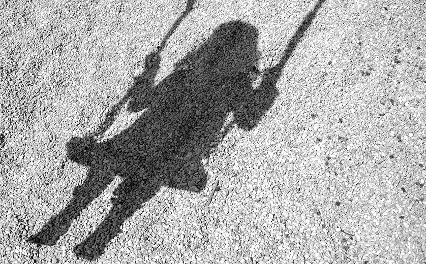 Shuttersock image of the shadow of a child on a swing.